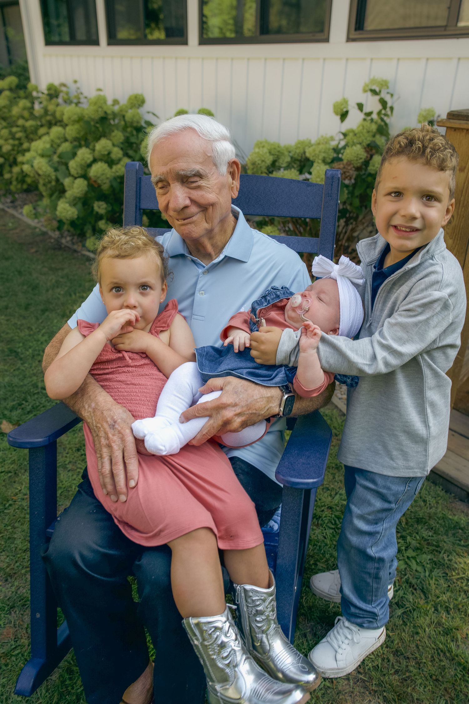 A heartwarming sequence of candid moments shared between a young child and elderly person on a blue bench outdoors.