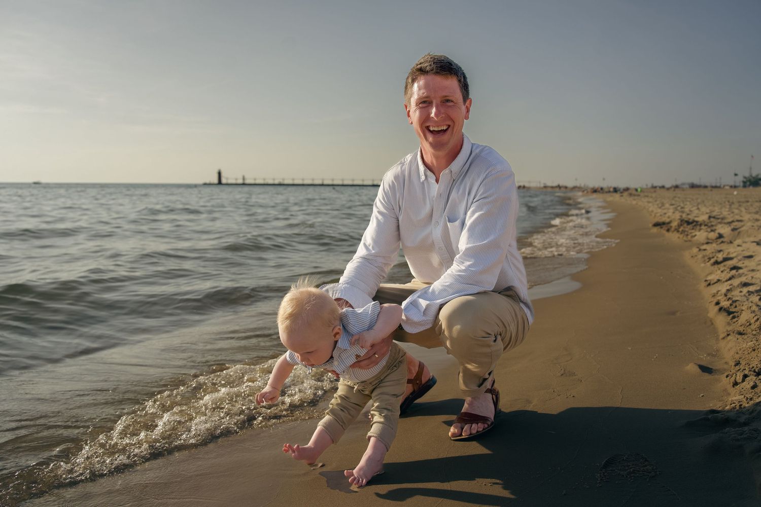 A person enjoying a peaceful moment at the beach during sunset while sitting on the sandy shore near the ocean waves.