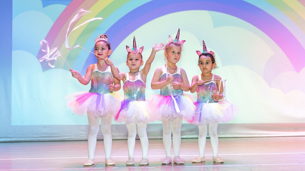 Young ballerinas performing basic ballet positions at a Dubai dance school