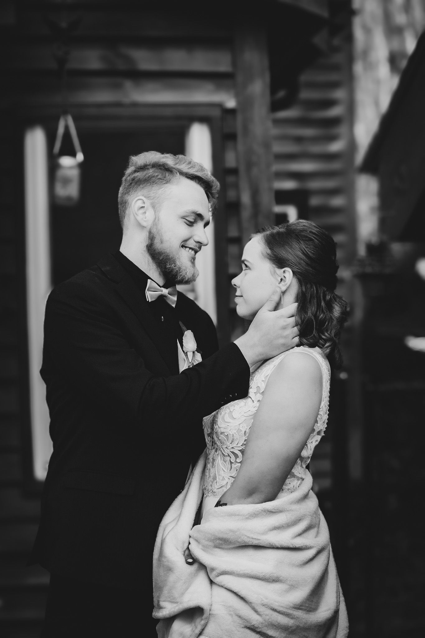 A romantic black and white portrait of newlyweds sharing an intimate moment.