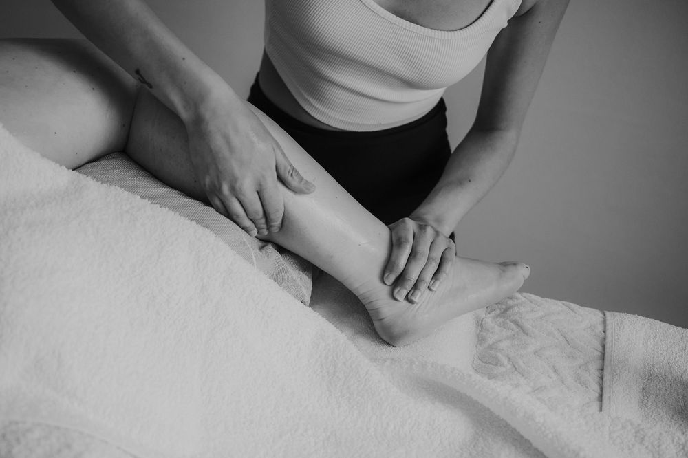 Close-up of hands performing therapeutic massage techniques on a person's back.