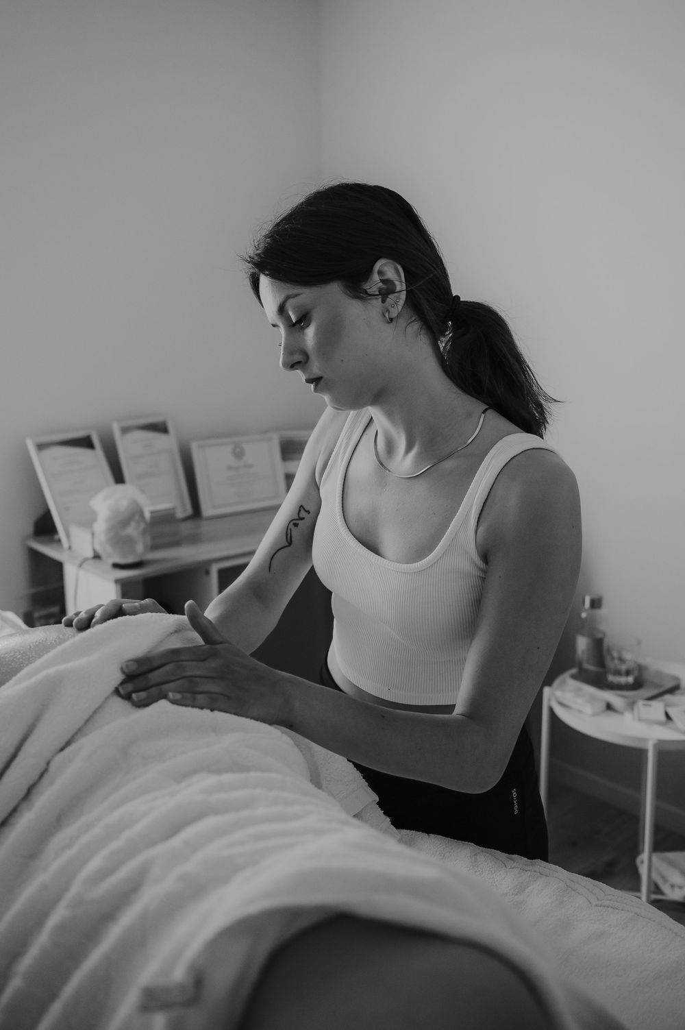Massage therapist performing treatment on client on massage table in serene spa setting.