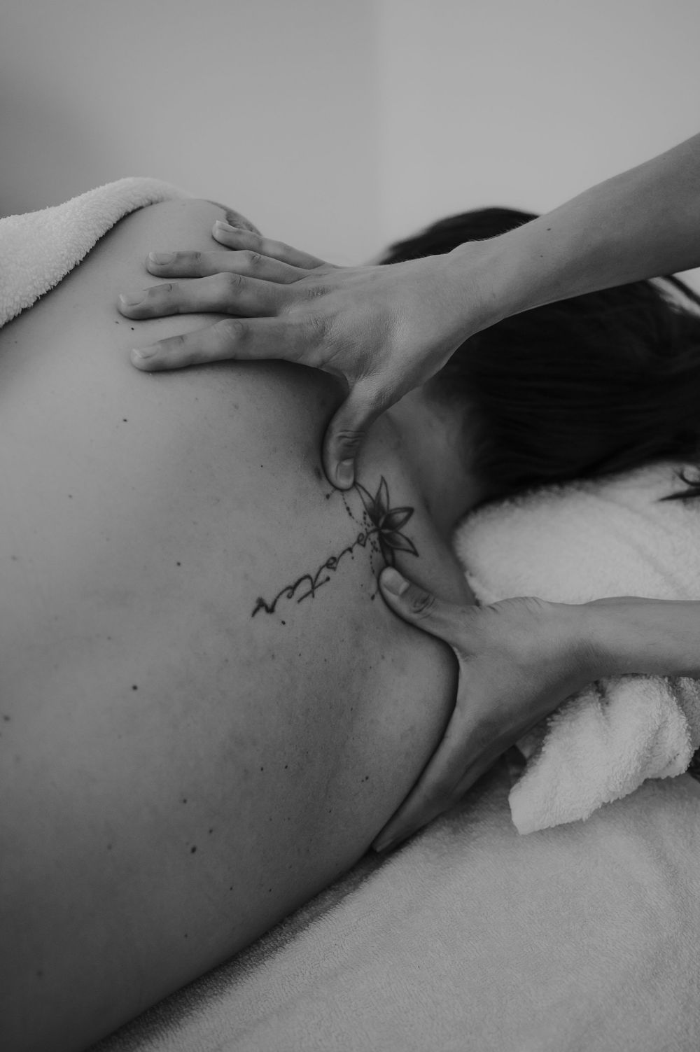 Professional massage therapist applying deep tissue pressure techniques shown in black and white.