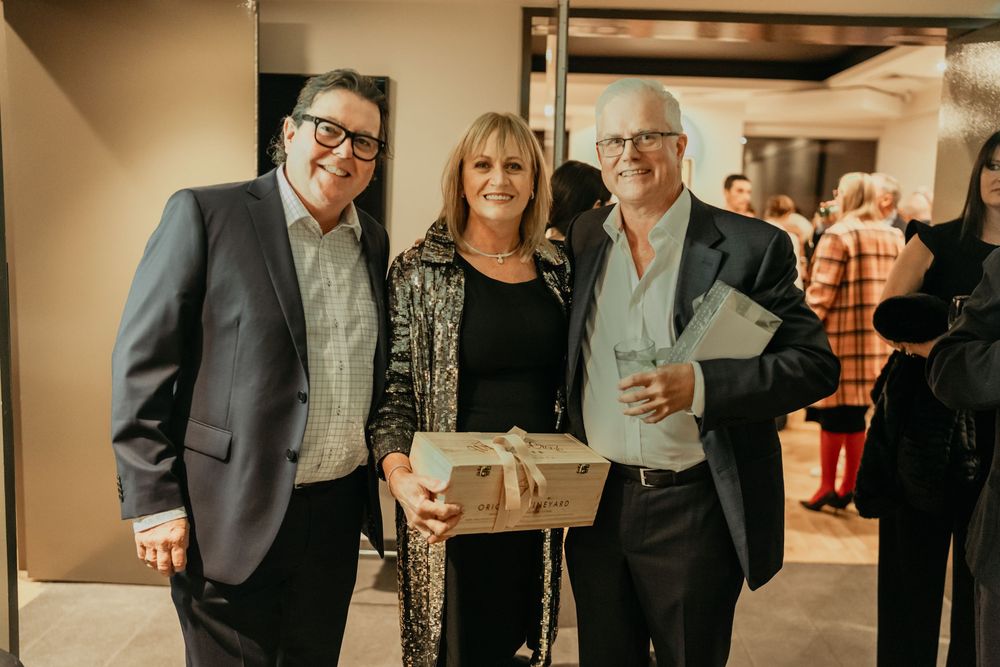 A group of people mingling and socializing at a business or networking event with drinks in hand.