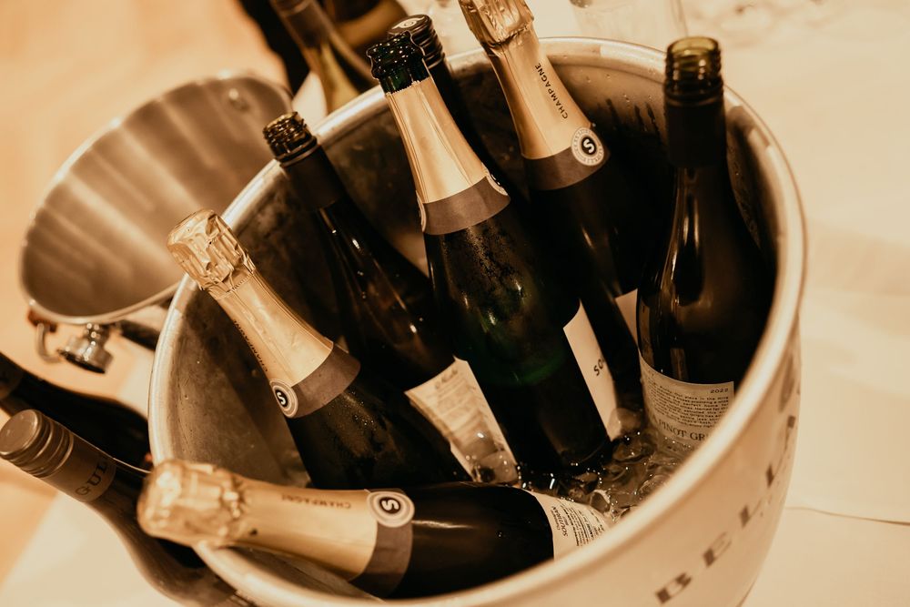 Bottles of wine and champagne chilling in an ice bucket with a vintage sepia tone effect.