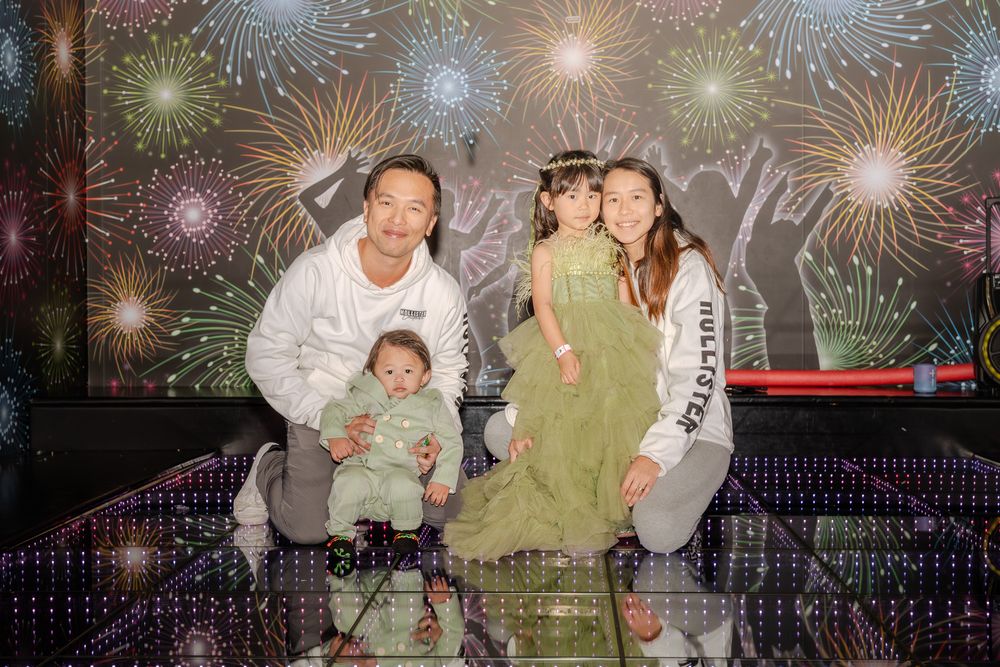 Group gathered outdoors watching vibrant fireworks display illuminate the night sky with colorful bursts of light.