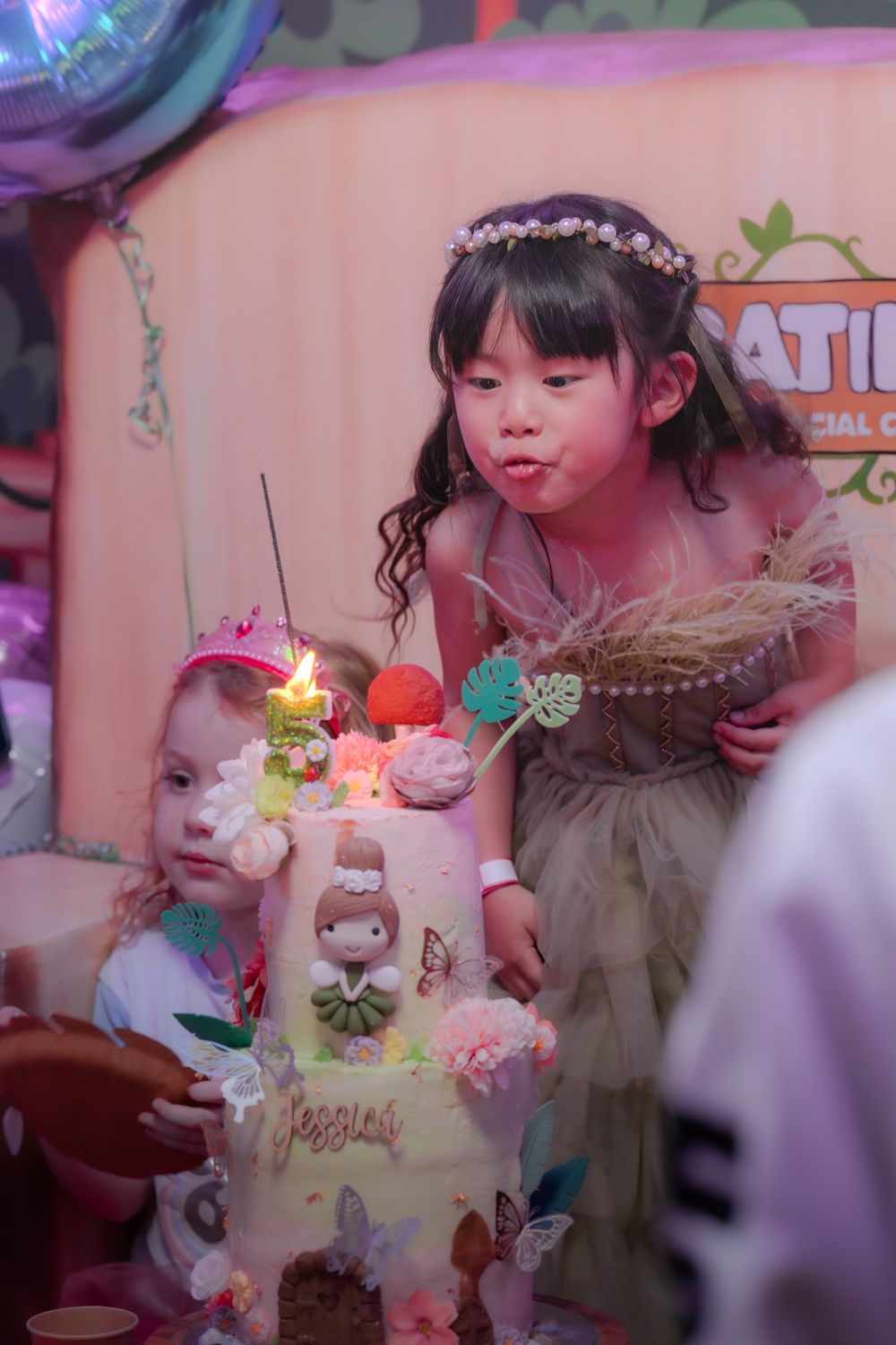 A birthday celebration scene with a decorated cake featuring candles and ornate decorations in pink and pastel tones.