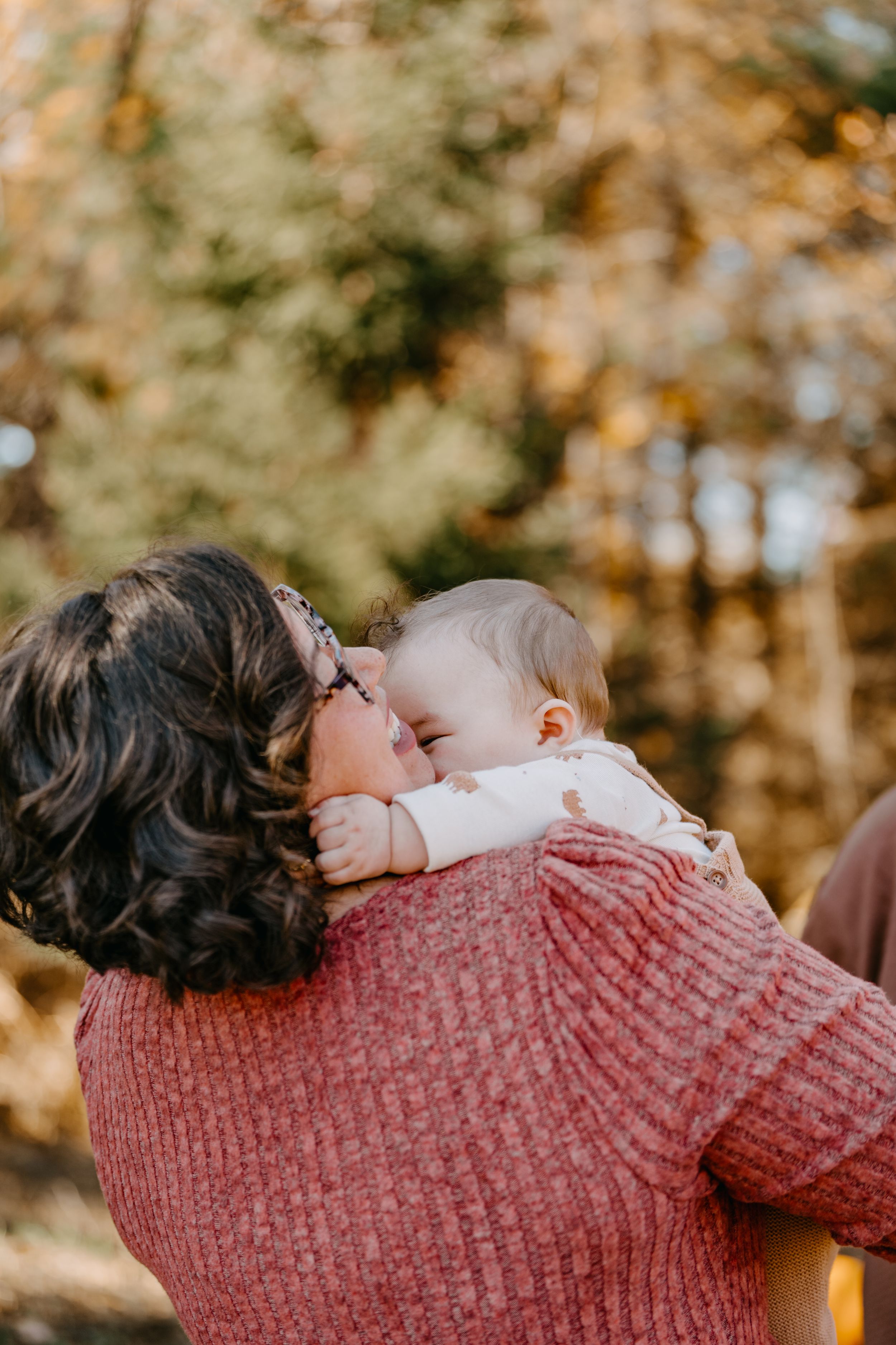 A warm autumn family moment captured in a series of loving interactions against a golden forest backdrop.