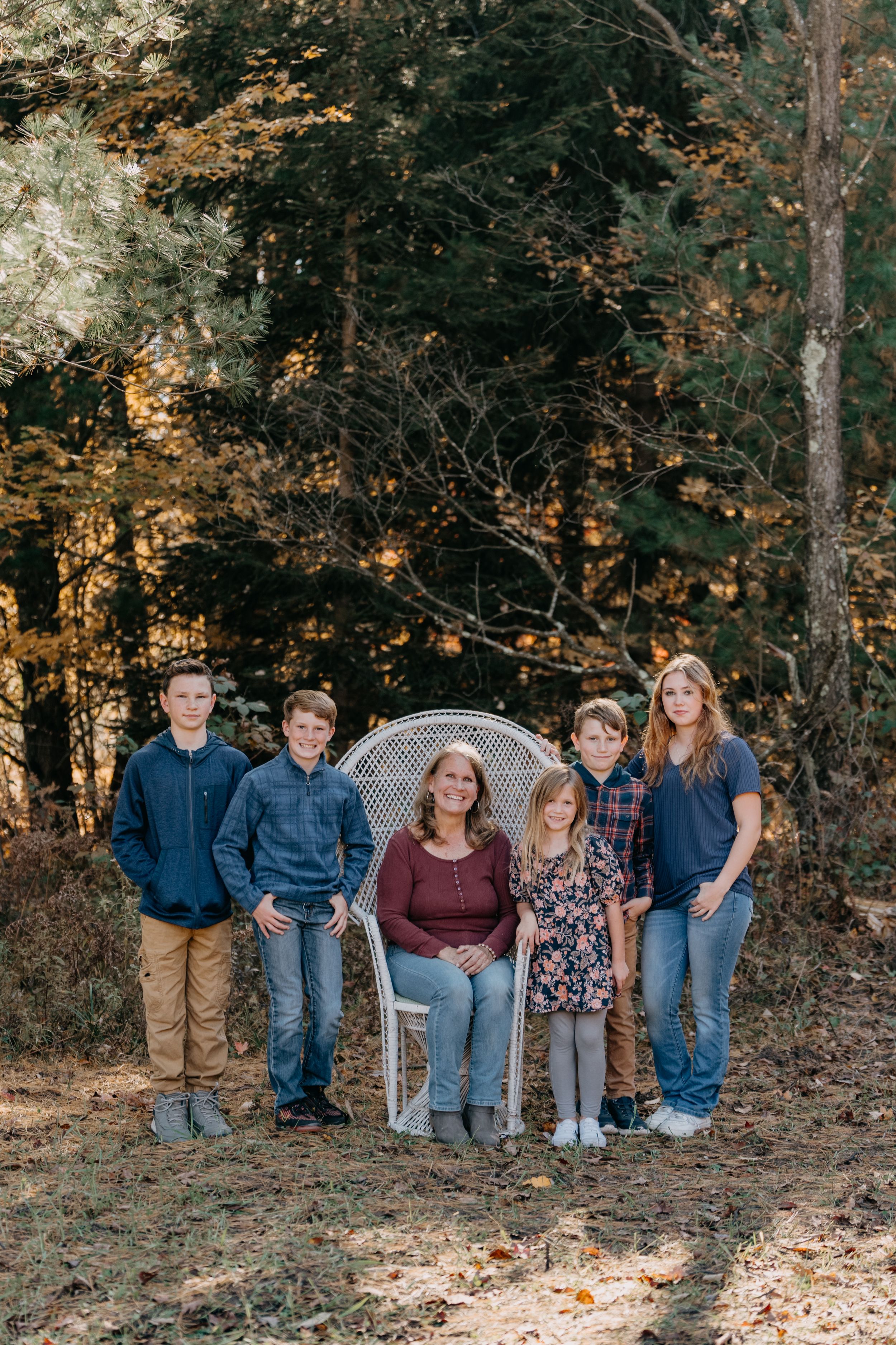 Group portrait in wooded setting with autumn leaves and natural lighting.