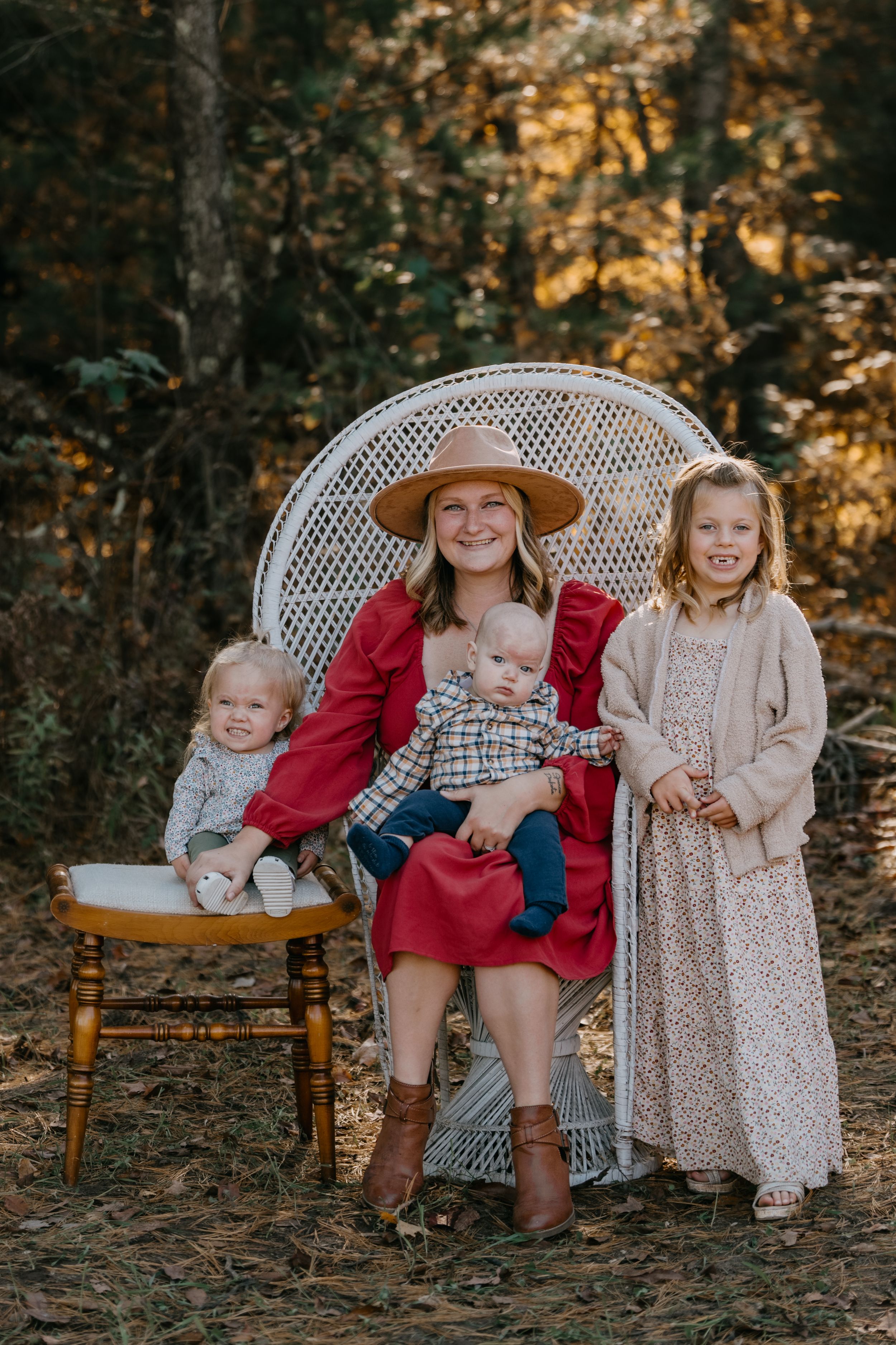 Children sit together on a vintage wooden bench in an autumn forest setting with warm golden lighting.