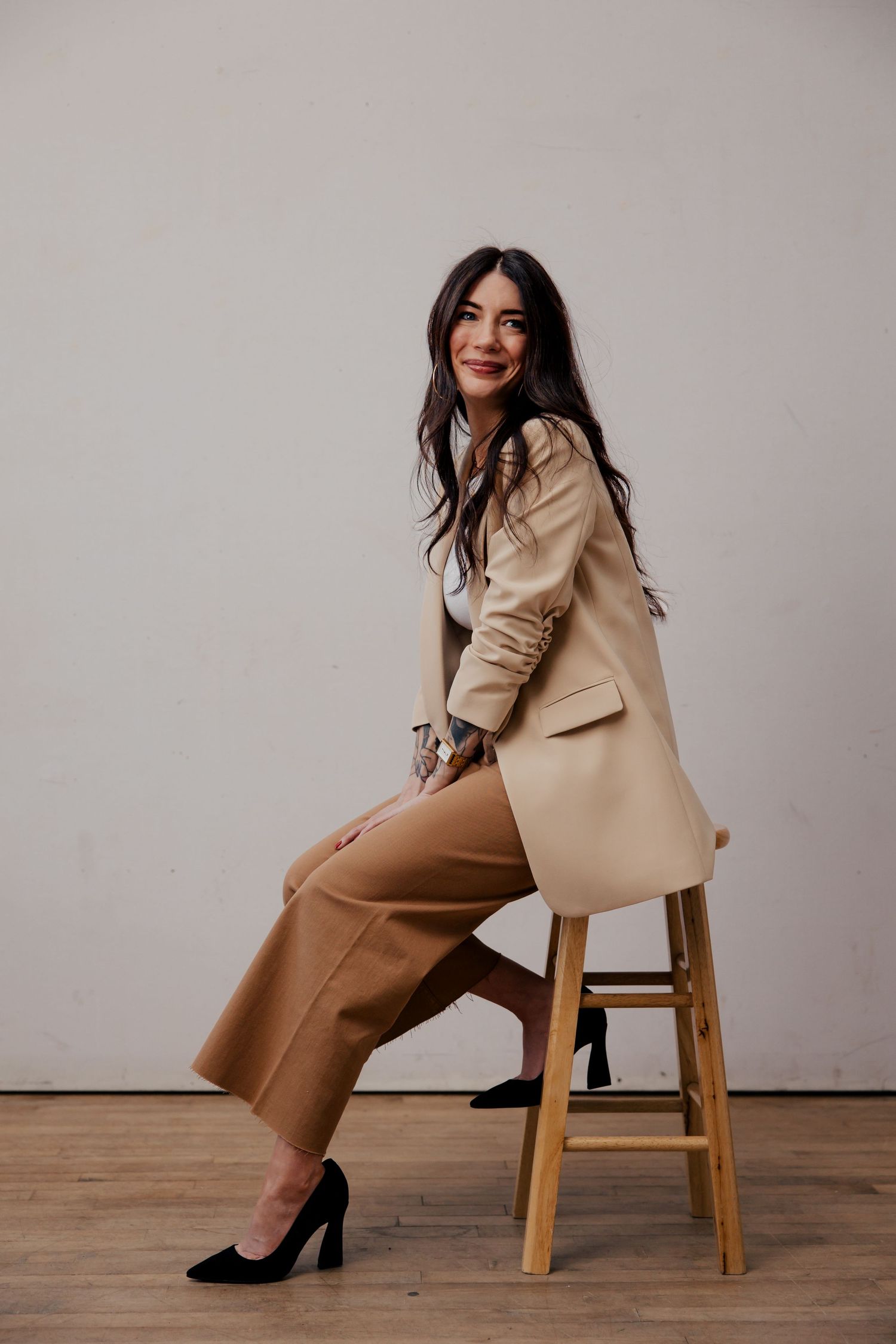 Fashion look featuring brown wide-leg pants paired with cream blazer and heels in minimalist photo series.
