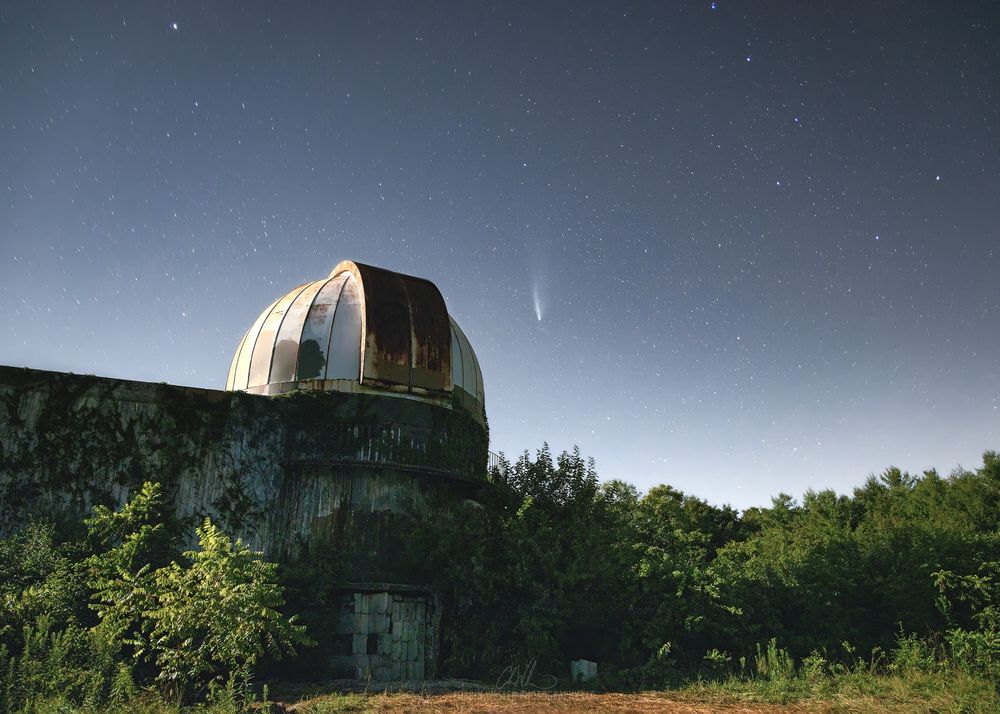 Nighttime view of an abandoned observatory in Illinois with Comet NEOWISE.