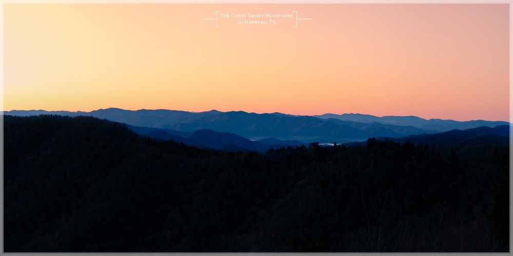 Sunrise over the Smoky Mountains creates a pink and orange gradient sky with the mountains silhouetted.