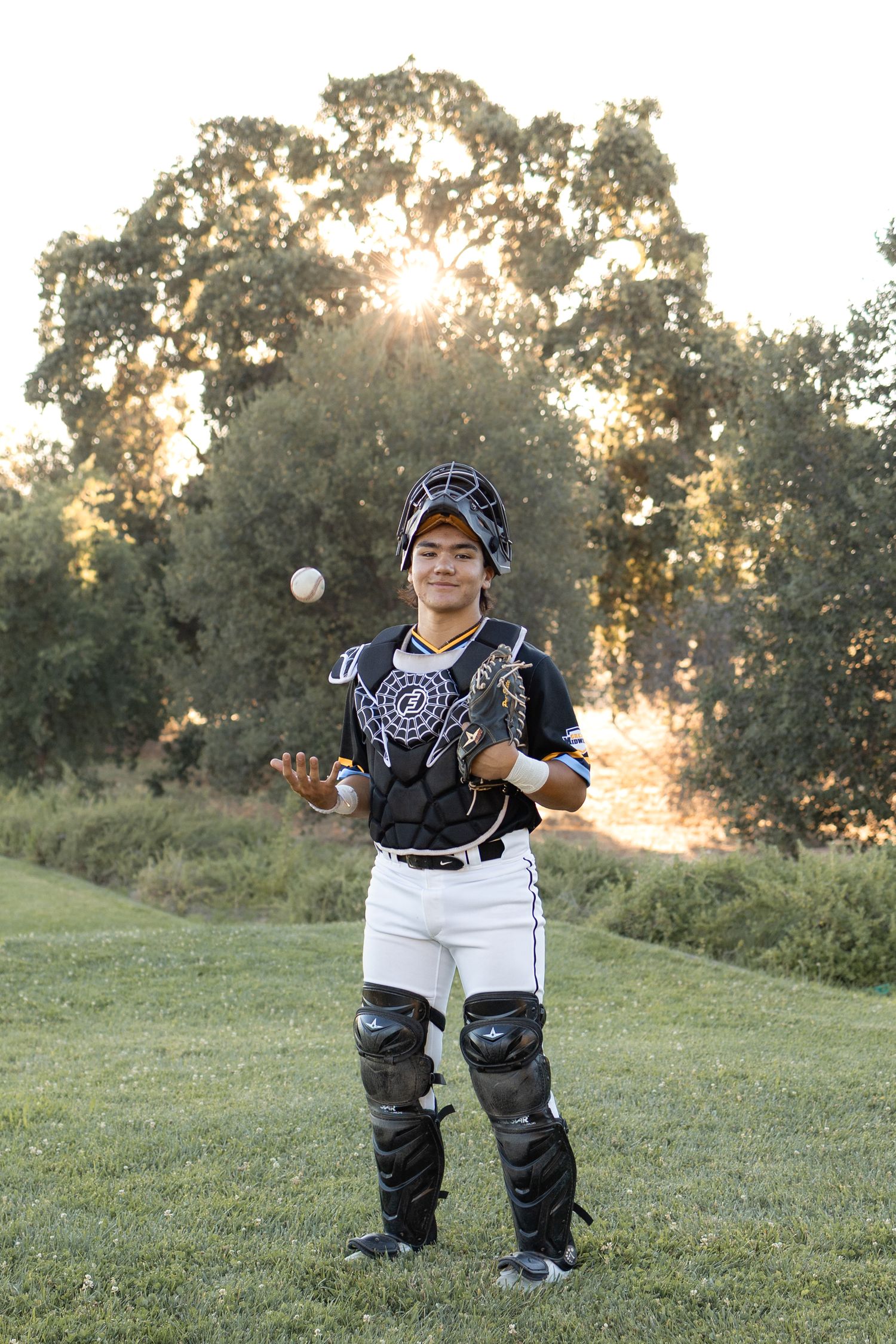Vanden high school senior portrait of Asian male student in baseball gear in front of trees