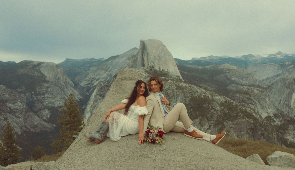 People enjoy scenic mountain views while sitting on the edge of Half Dome in Yosemite National Park.