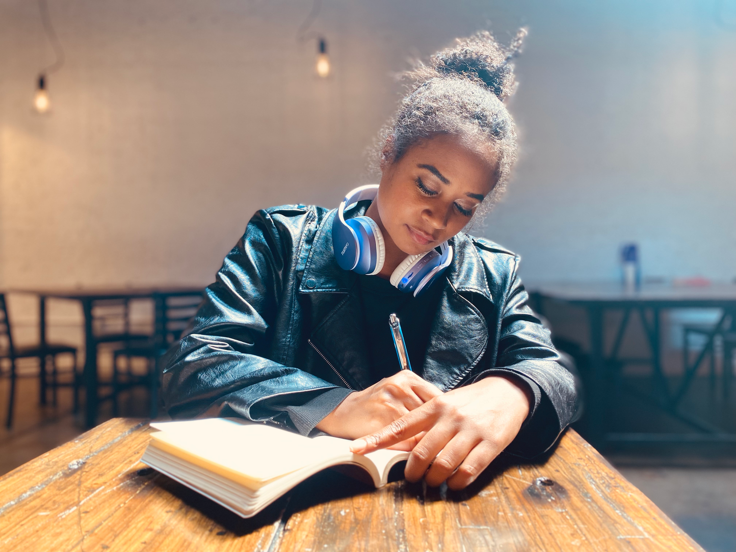 Lauren J Williams, Disney Ice Skater and yoga instructor, writing in her journal at a coffee shop. Image by Alex Kent