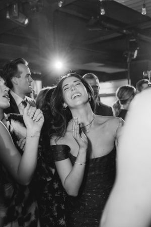 People dancing and enjoying themselves at a nightclub with dramatic lighting captured in black and white.
