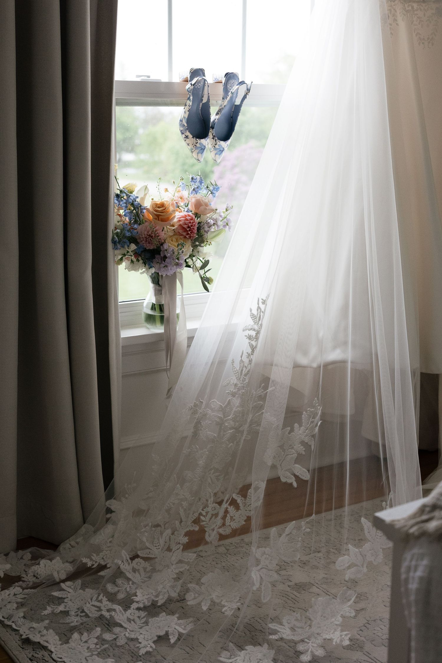 White and peach floral centerpieces with garden roses and delicate greenery adorn elegant wedding reception tables.