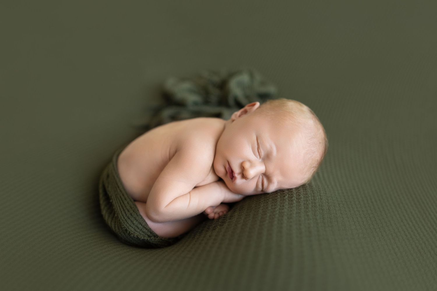 Sleeping newborn rests on textured olive green backdrop. Photos by Tampa Photographer DigitalMyst Photography