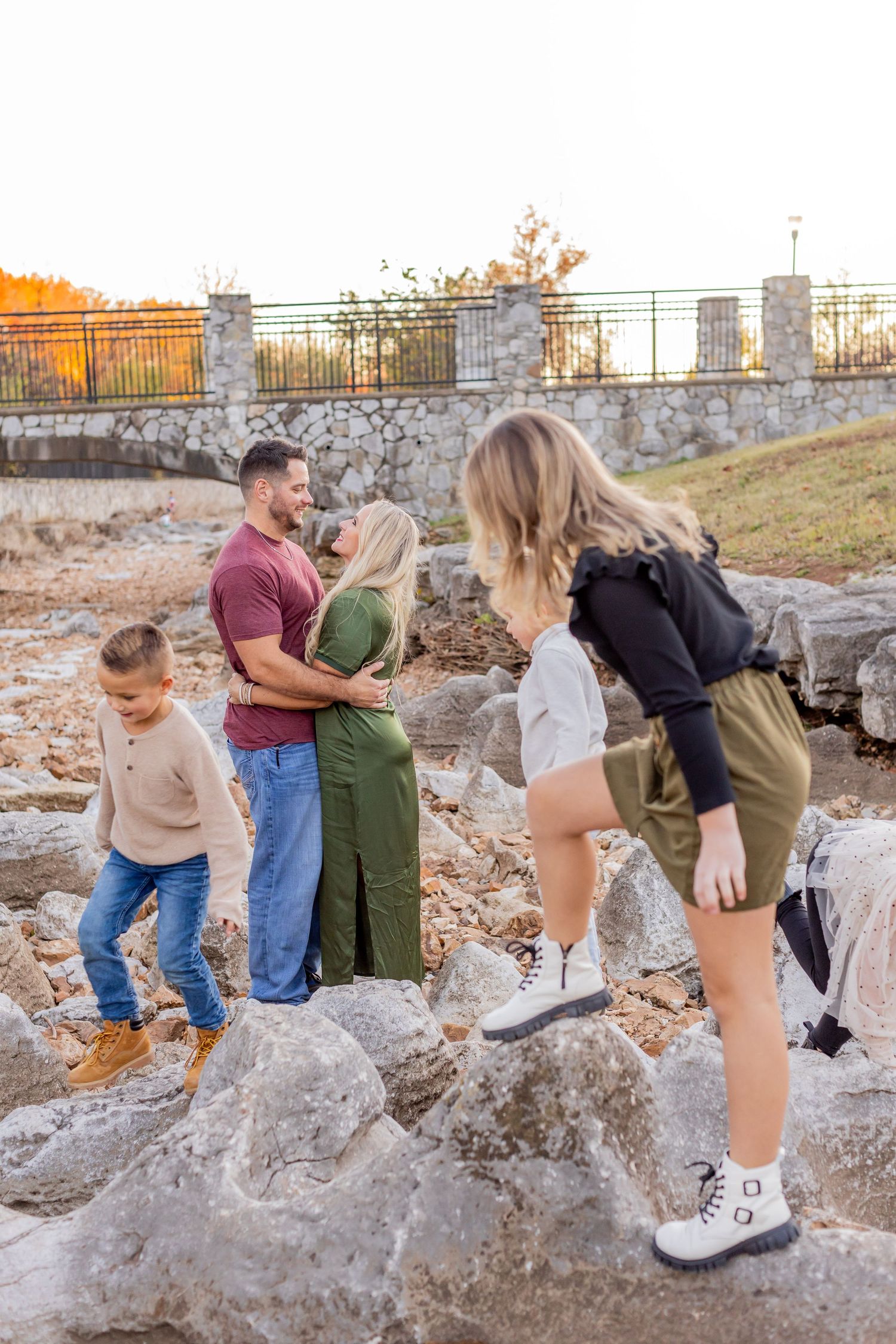 A couple poses together on rocky terrain at sunset as a sequence shows a playful moment between them.