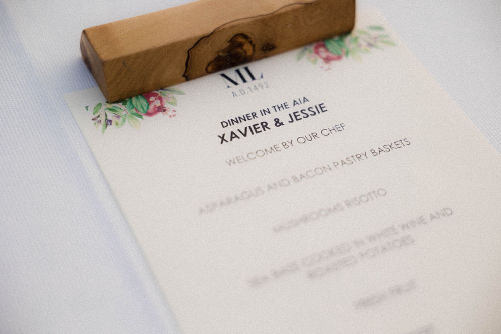 Close-up view of an elegant wedding invitation with brown box detail and floral design elements on white paper.