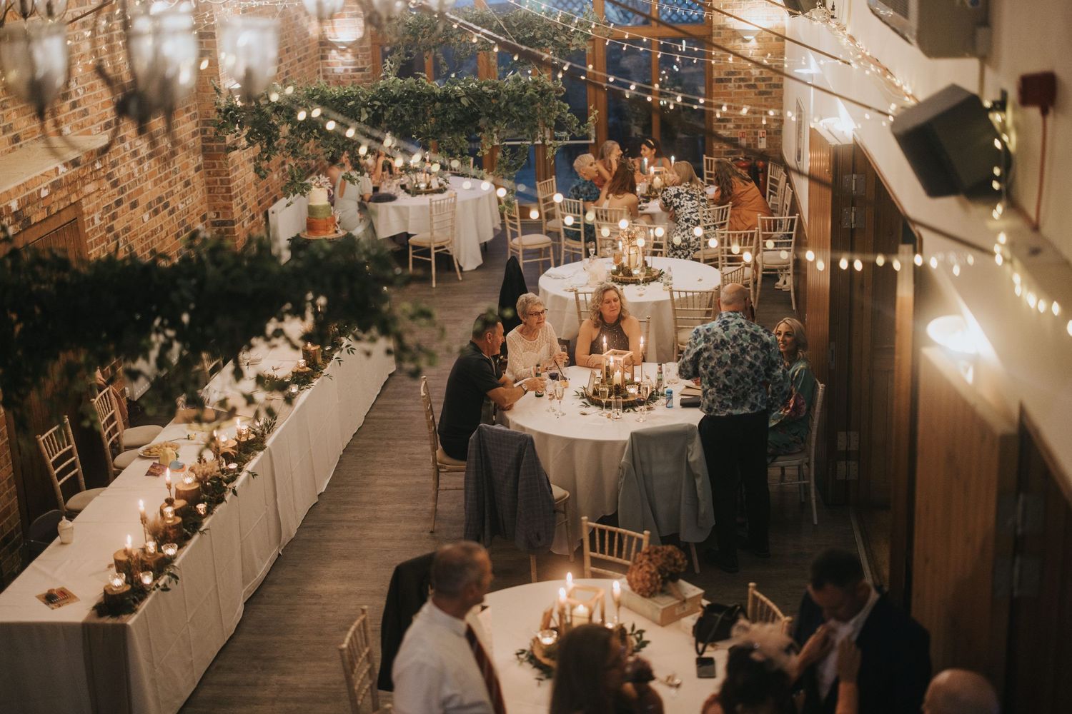 Hall Farm decorated with string lights and rustic elements featuring long dinner tables with candlelight - taken by Grimsby photographers.