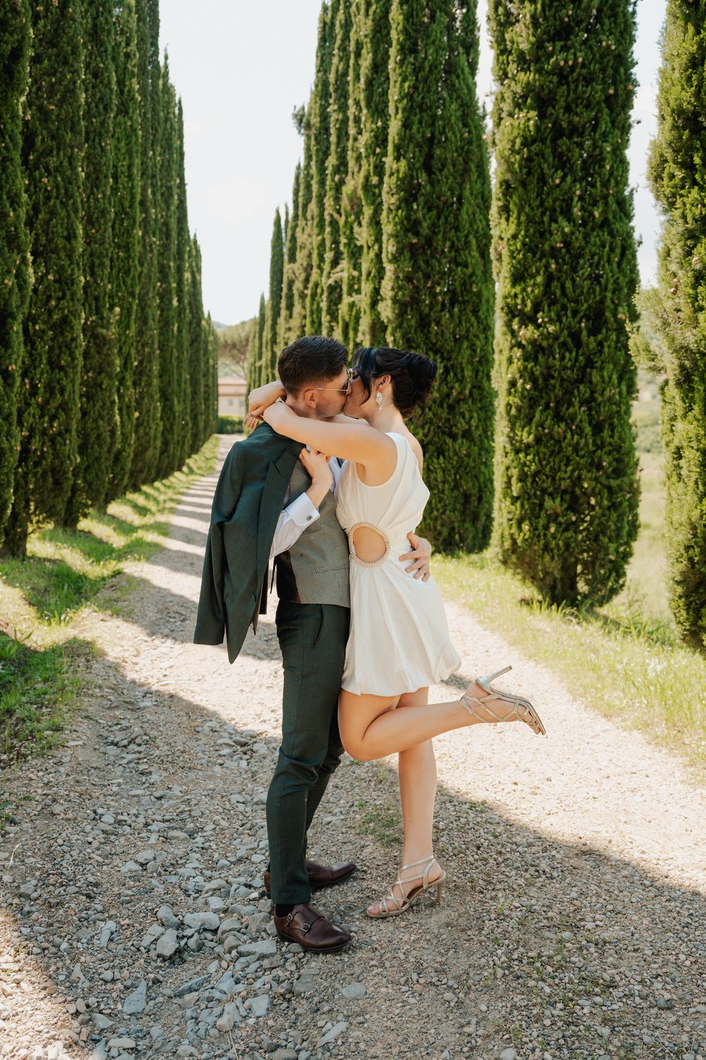 Luxury wedding session – para młoda idzie w alei cyprysów w Toskanii, fine art fotografia ślubna.