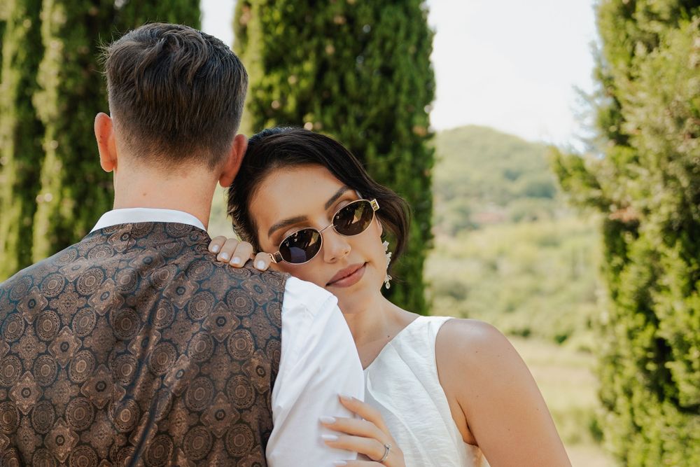 Luxury wedding – romantyczny spacer pary młodej między cyprysami w Toskanii, fotograf ślubny.
