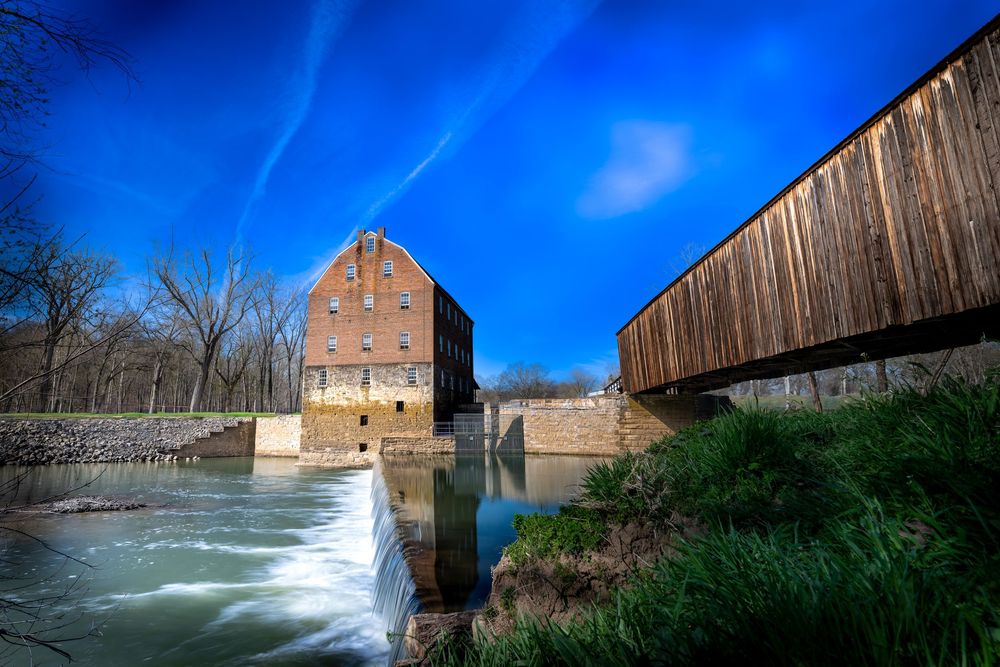 Historic Dillard Mill stands beside rushing waters on a spring day along Huzzah Creek in Missouri.