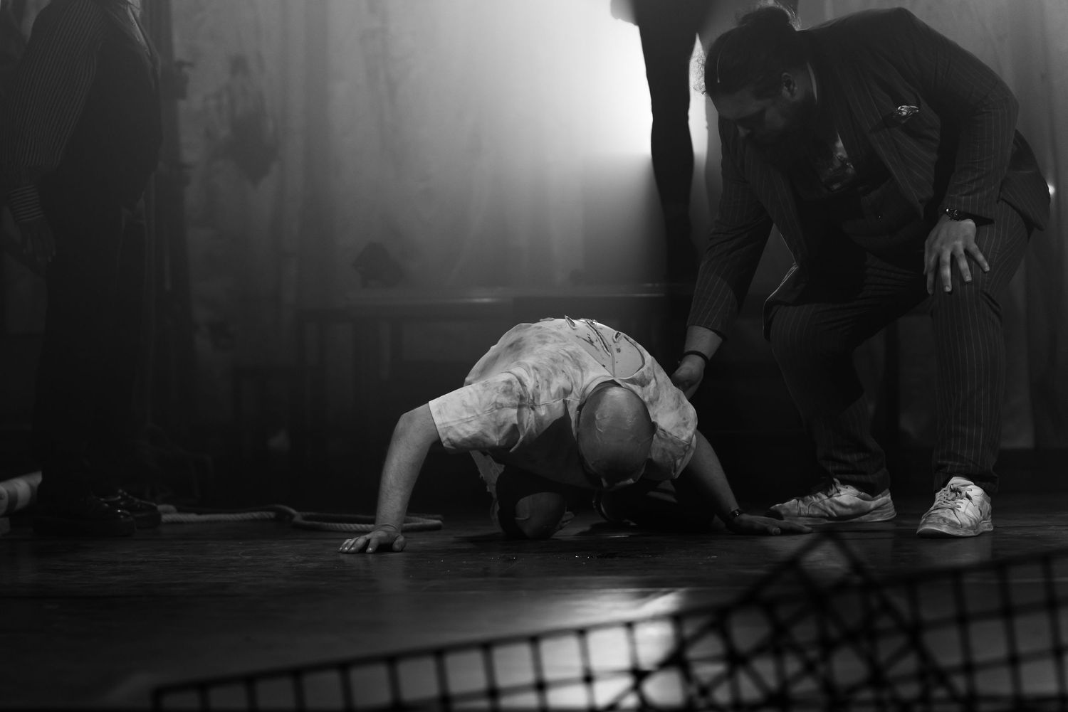 Low-angle performance shots on a dark stage with dramatic lighting.