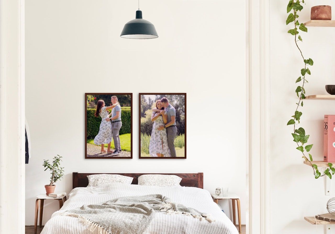 Bright bedroom interior with white bedding and personal photo gallery wall.