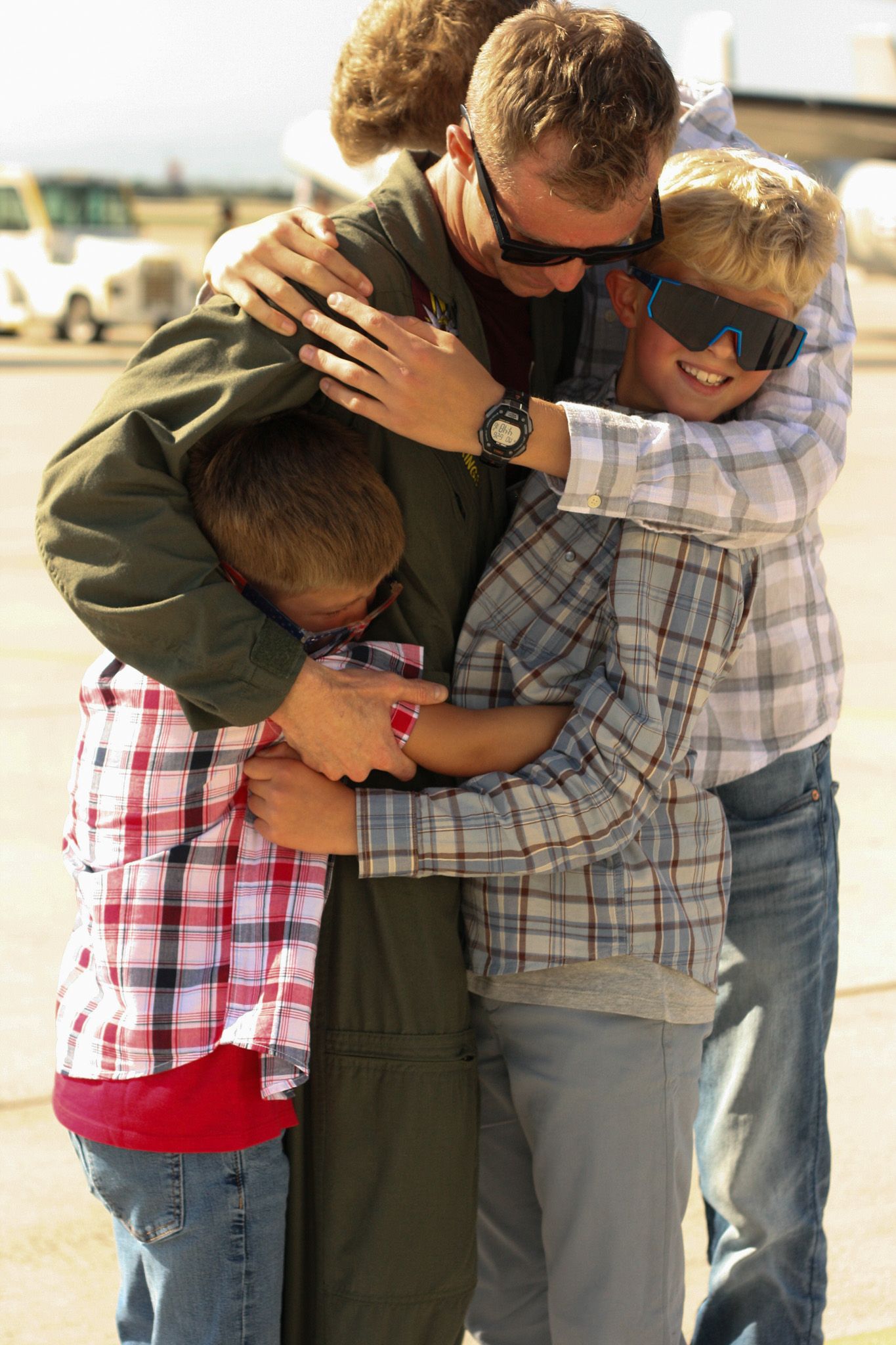 Group of children hugging and embracing outdoors in casual clothing.