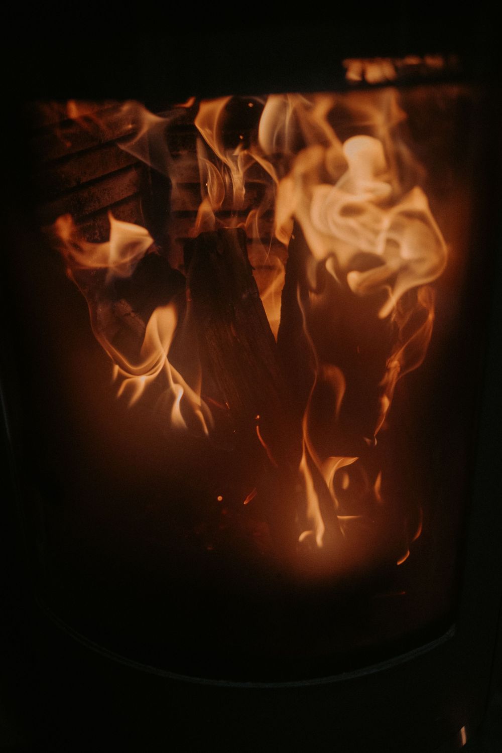 Close-up of dancing orange flames in a dark fire pit.