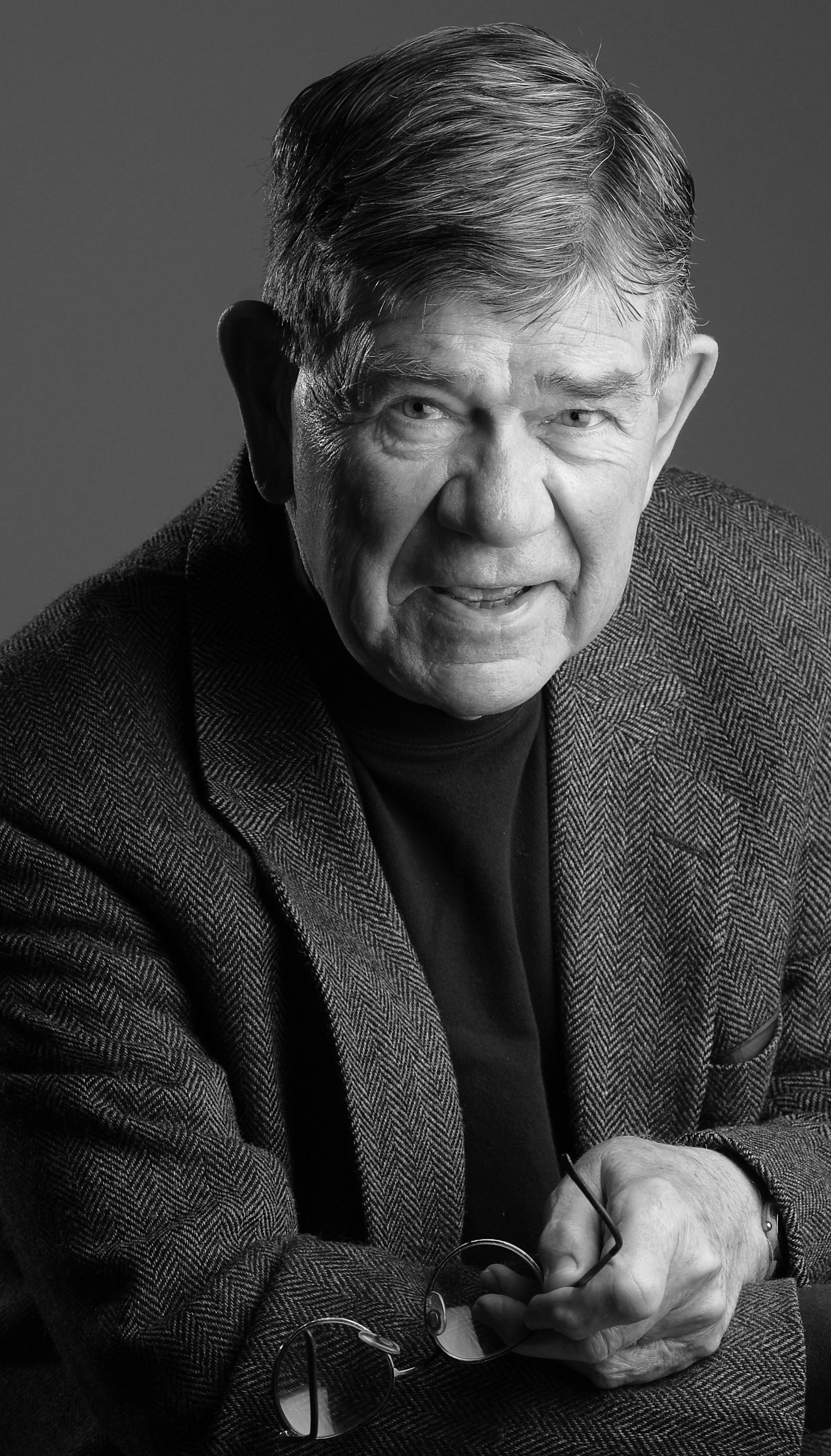 Black and white portrait of a senior man in a dark sweater smiling warmly at the camera | photo by Tom McCall Photography | Maryland Photos