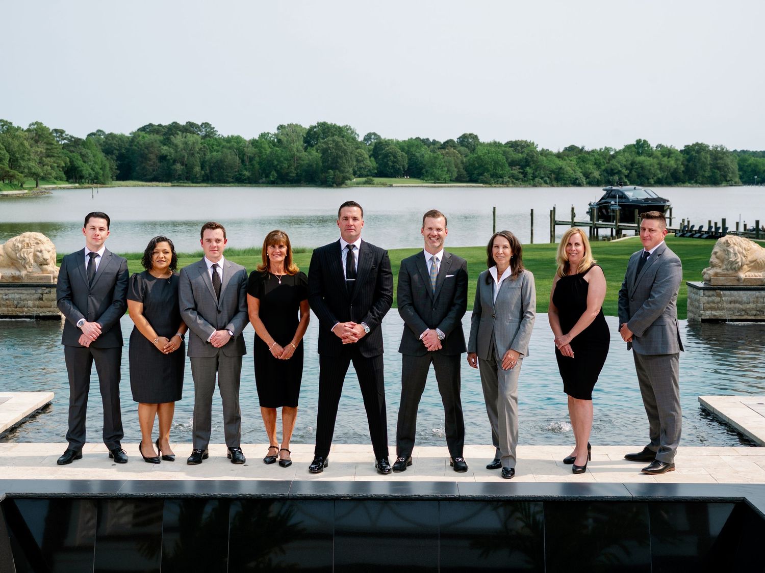 Wedding party members lined up showing their shoes and feet along a waterfront dock in a creative photo composition.