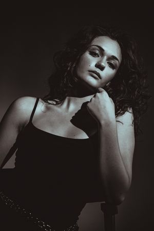 A dramatic black and white portrait series showing artistic poses with moody lighting and dark shadows.