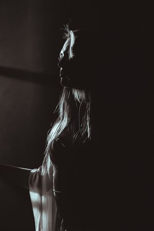 A series of moody black and white portraits showing a silhouetted figure in dramatic lighting and poses.