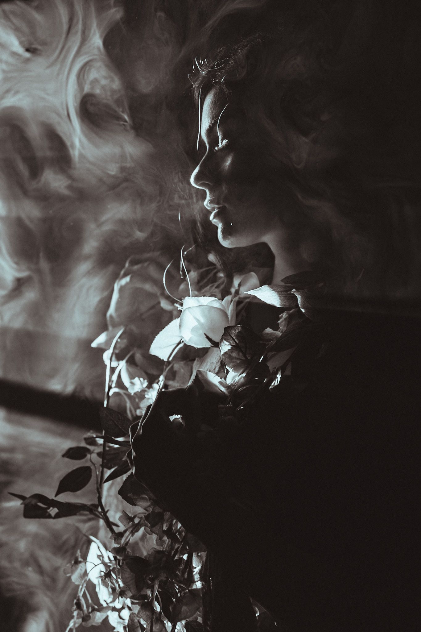 Artistic black and white photographs showing ethereal smoke swirling against a dark background in dramatic patterns.