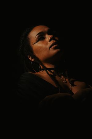 Dramatic side profile silhouettes against dark background show artistic portraits in moody lighting.