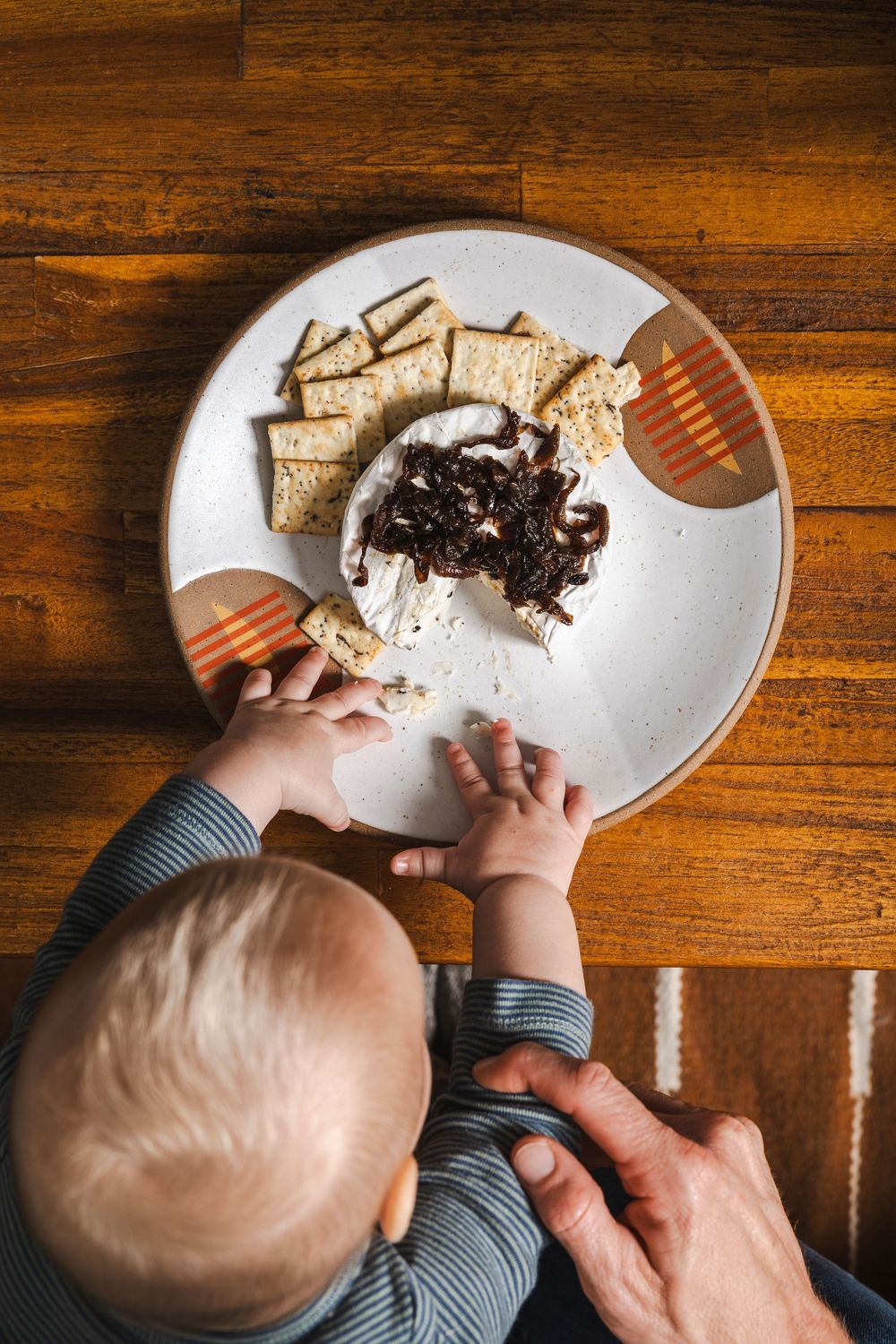 A sequence of images showing hands assisting with eating a dessert on a white plate against a wooden table background.
