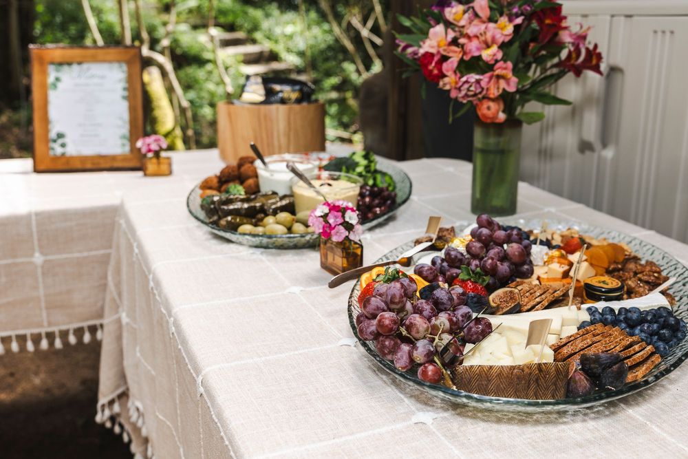 Elegant buffet spread featuring assorted pastries, fruits, and appetizers arranged on white serving platters.