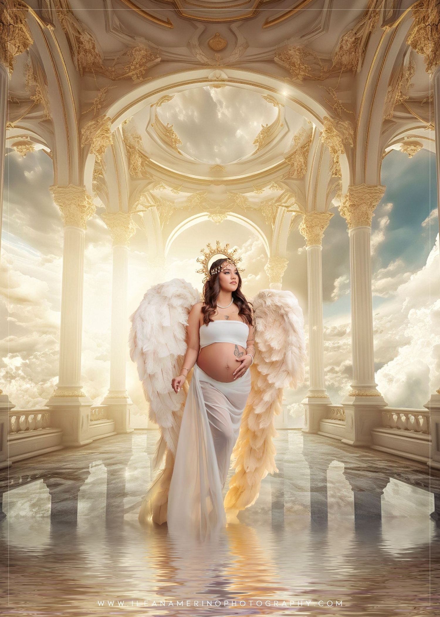 Pregnant woman in white gown with angel wings and crown poses in golden celestial palace setting.