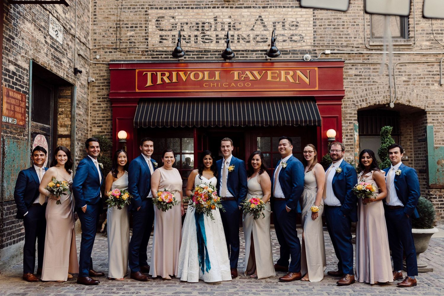 Wedding party lined up against brick wall outside Tivoli Tavern.