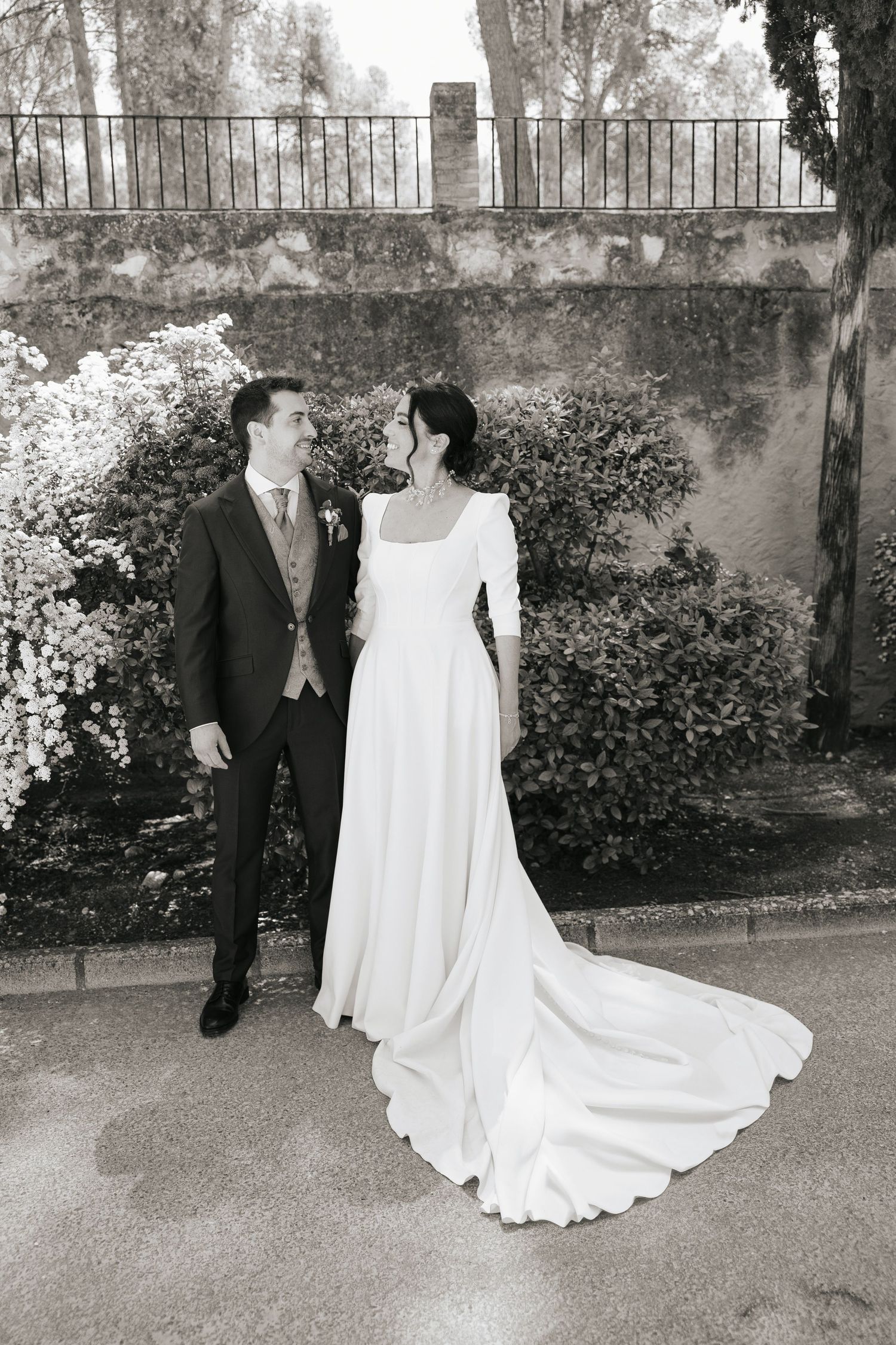 Couple sharing intimate moments on a wooden boardwalk surrounded by lush greenery and natural foliage.