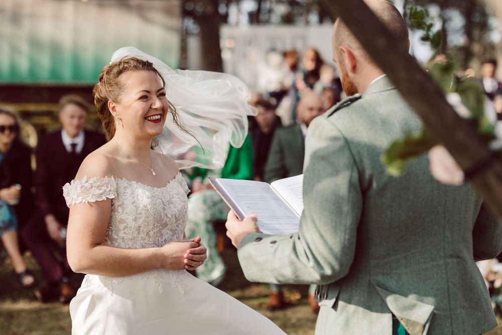 Wedding guests dance and celebrate outdoors during a joyful reception celebration.
