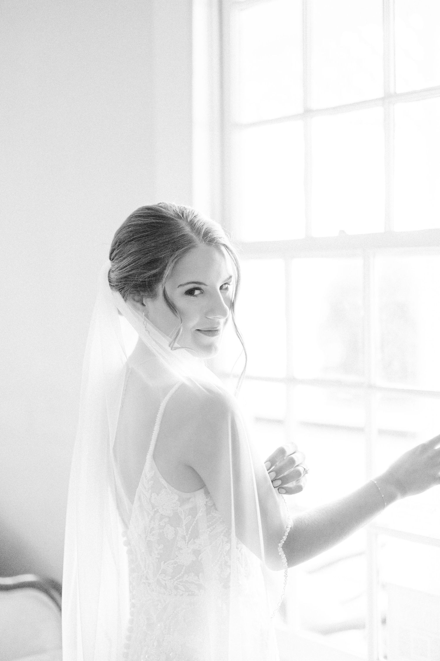 Ethereal bridal portrait in soft natural light showing delicate lace details and romantic styling.