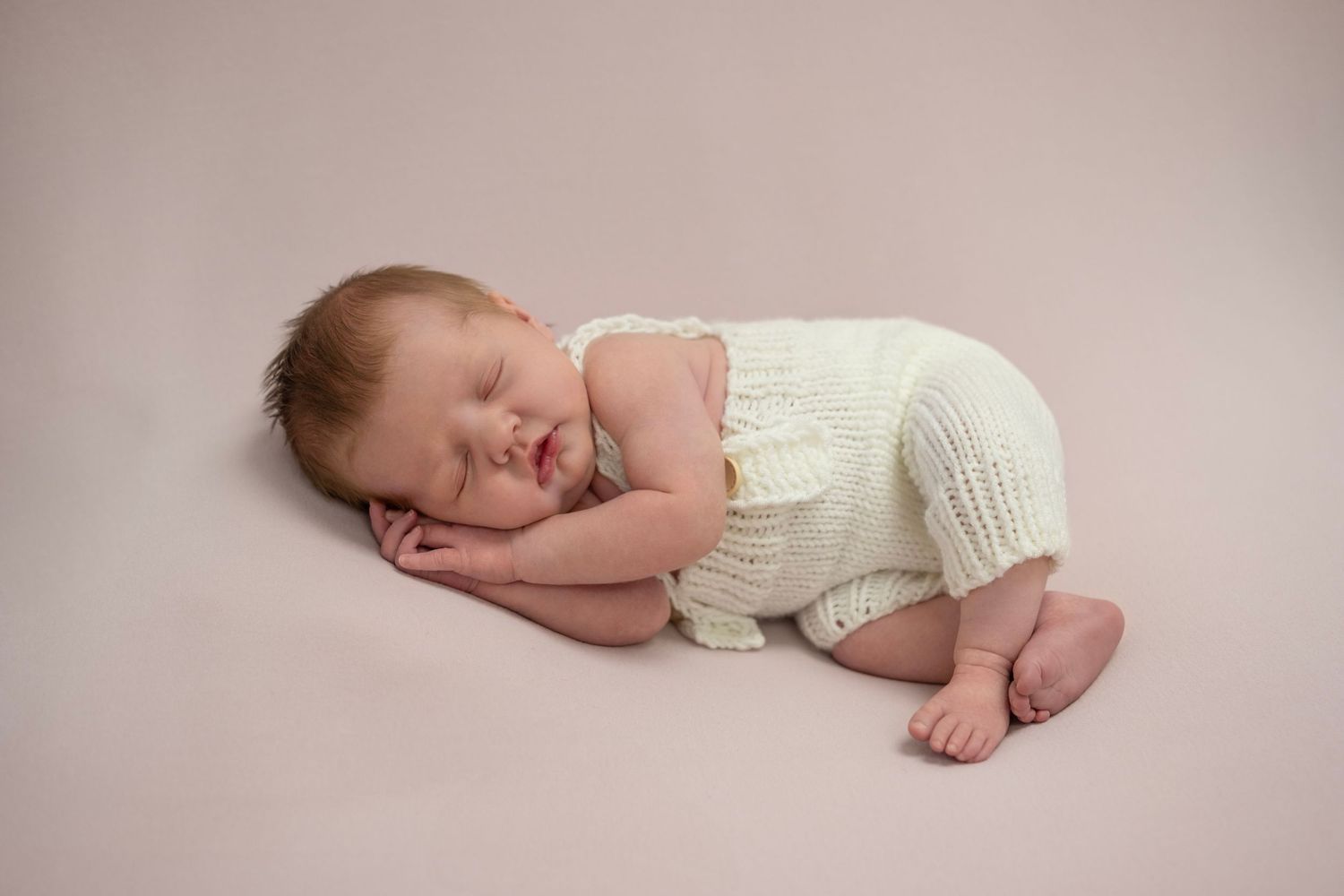 Newborn girl posed on her side — in-home newborn photography near Devizes