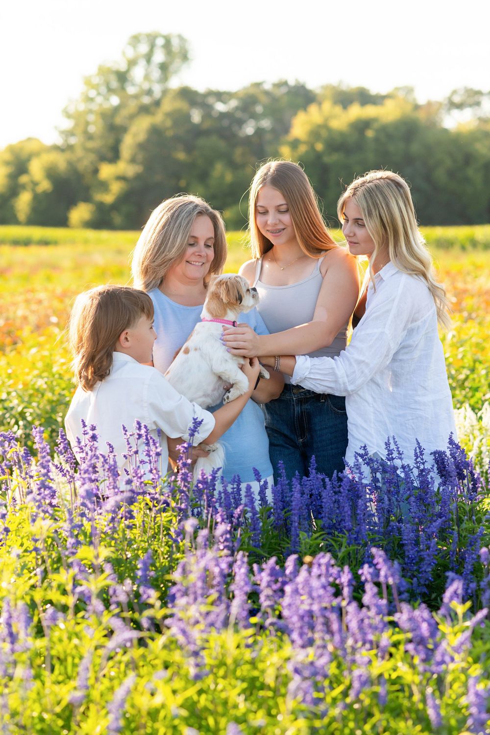 A group sits together in a blooming field of purple lupine flowers at golden hour the Flower Lady & Gent FLOWER FIELD.