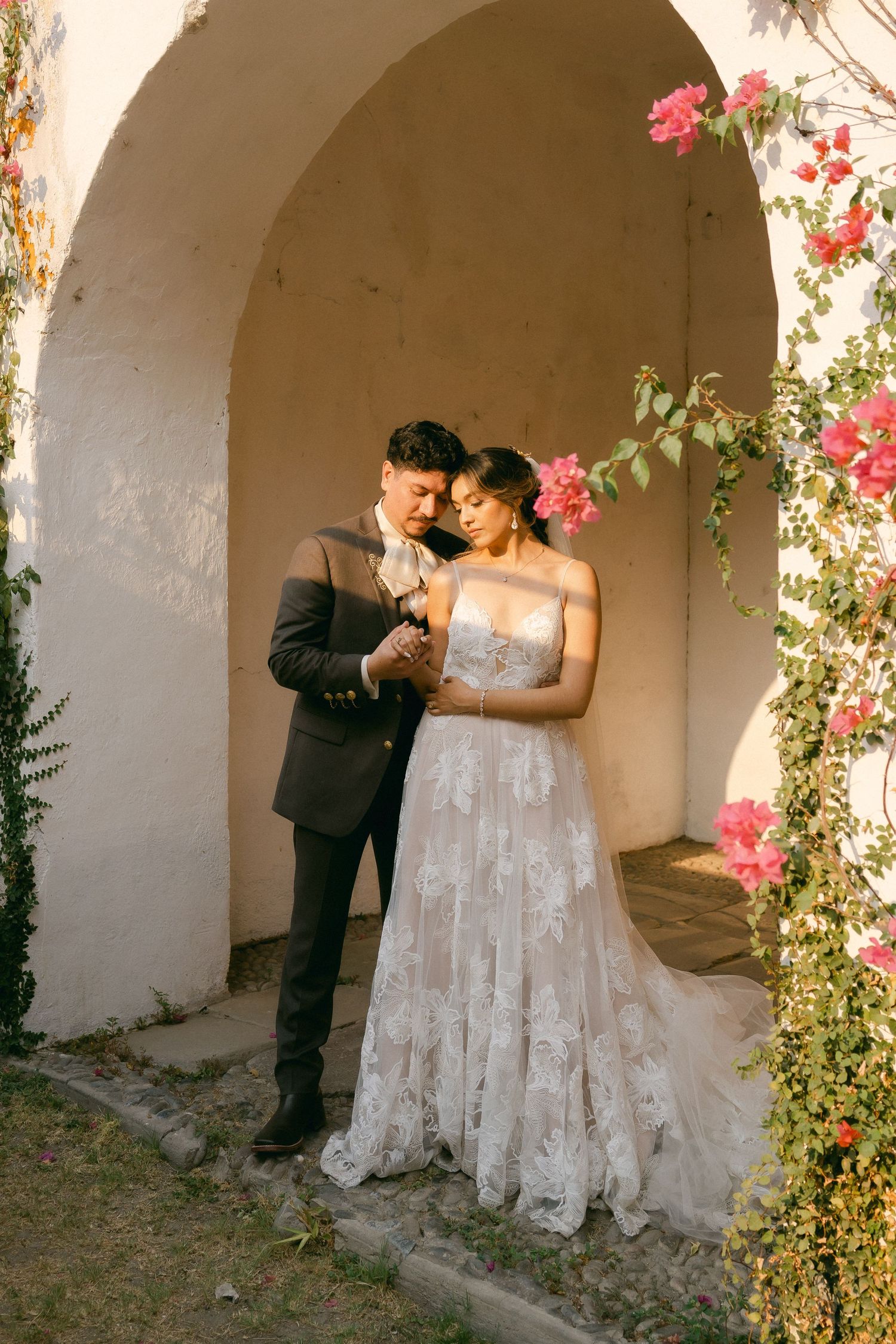 A romantic wedding scene in an arched doorway adorned with pink bougainvillea flowers.