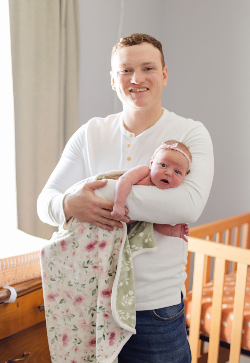 Candid shots of parents cuddling with their newborn baby wrapped in a floral blanket.